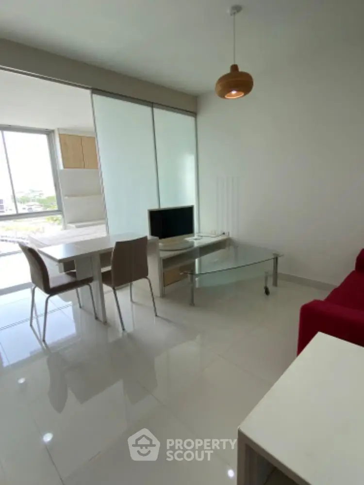 Modern living room with sleek furniture and large windows offering natural light.