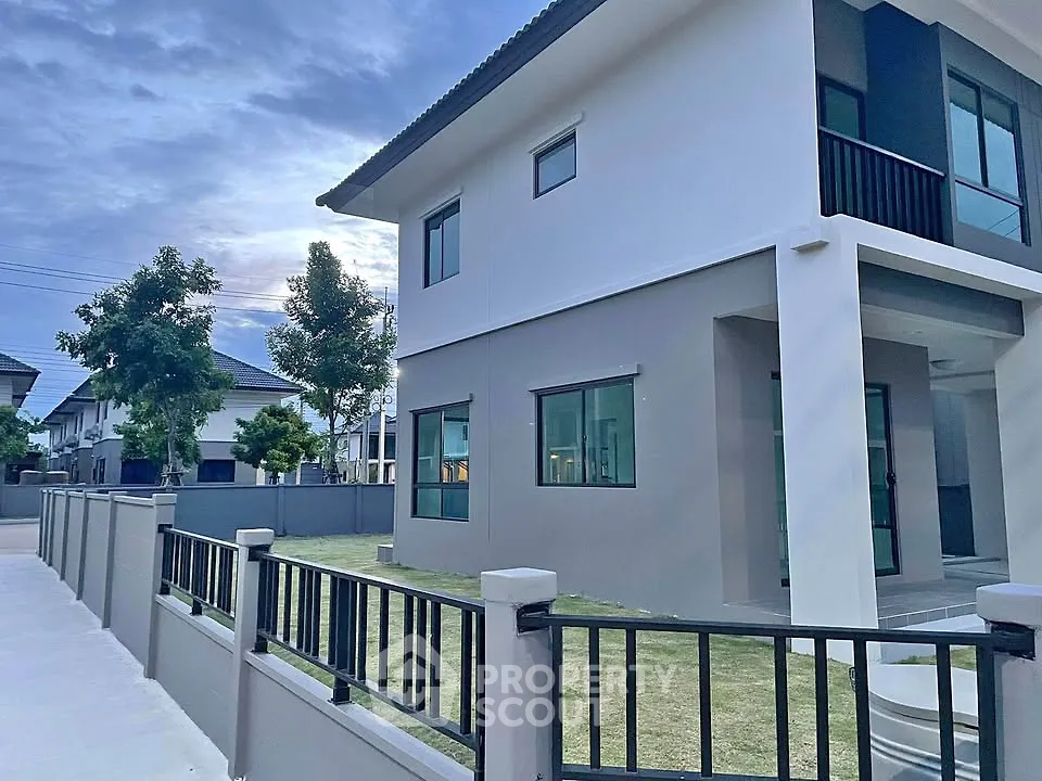 Modern two-story house with sleek design and spacious yard in a serene neighborhood.