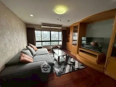 Spacious living room with city view, modern furniture, and large TV for ultimate comfort.