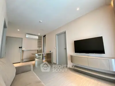 Modern living room with sleek design and wall-mounted TV in a stylish apartment.