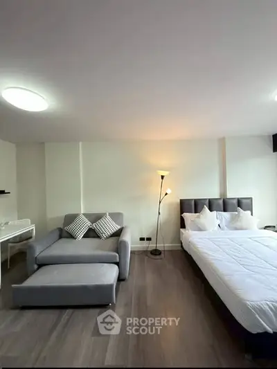 Modern studio apartment with cozy living area and stylish bedroom setup.