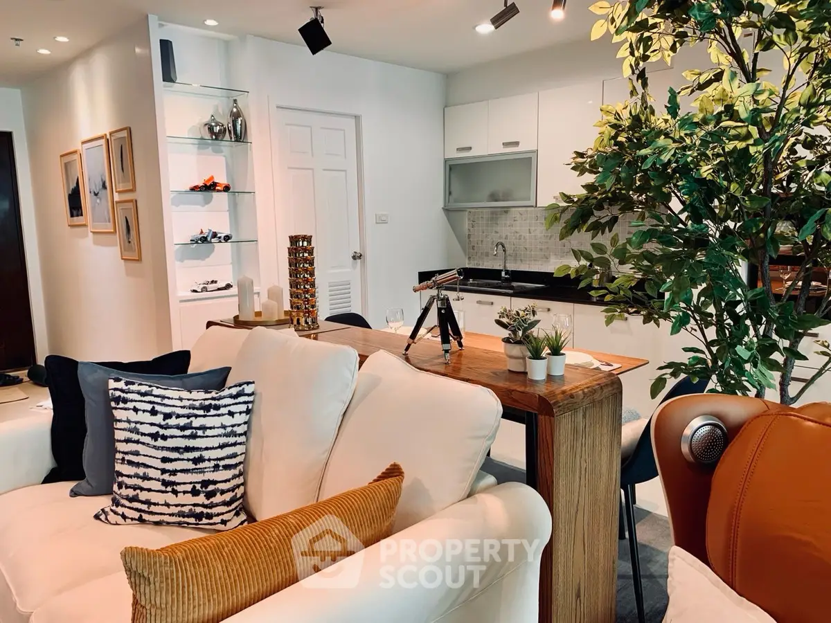 Stylish open-plan living room with modern kitchen and cozy seating area, perfect for entertaining.