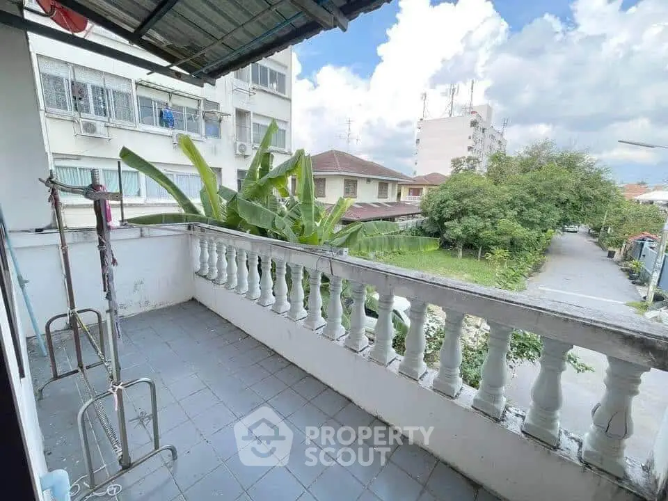 Spacious balcony with scenic neighborhood view and lush greenery.