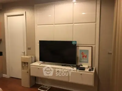 Modern living room with mounted TV and sleek storage unit, featuring a cozy ambiance.