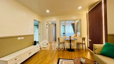 Spacious living room with modern decor and wooden flooring in a stylish apartment.