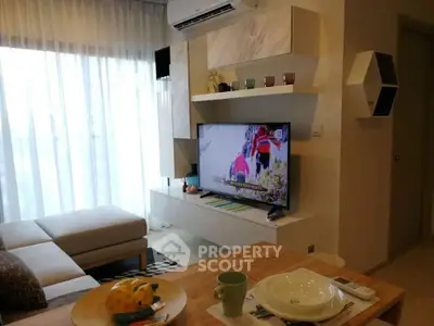 Modern living room with stylish decor and natural light, featuring a cozy sofa and wall-mounted TV.