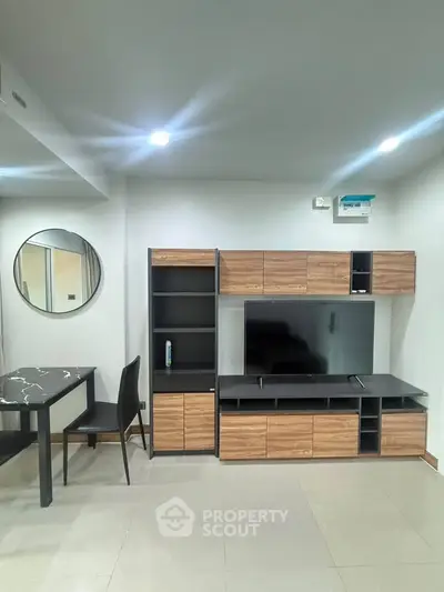 Modern living room with sleek furniture and stylish decor, featuring a TV unit and dining area.