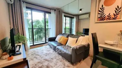 Chic living room with balcony view, modern decor, and cozy seating in urban apartment.