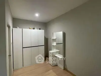 Spacious bedroom with modern wardrobe and sleek storage unit, perfect for organized living.