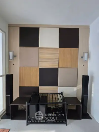 Modern living room with stylish wall paneling and sleek furniture setup.