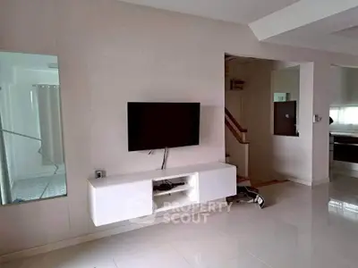 Modern living room with sleek TV setup and glossy tile flooring