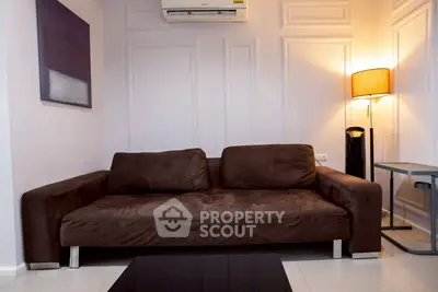 Modern living room with stylish brown sofa and elegant wall paneling