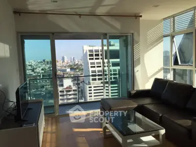 Modern living room with city view, featuring sleek furniture and large windows for natural light.