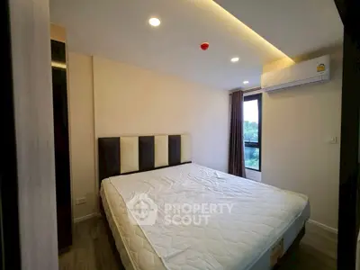 Modern bedroom with large window and air conditioning in a stylish apartment.