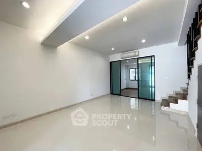 Spacious modern living room with sleek design and glass partition, perfect for contemporary living.