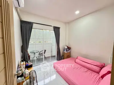 Cozy bedroom with pink bedding and balcony access in modern apartment