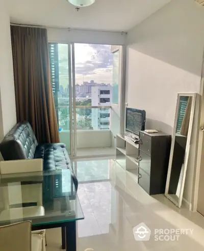 Modern living room with city view, glass table, and sleek furniture in a high-rise apartment.