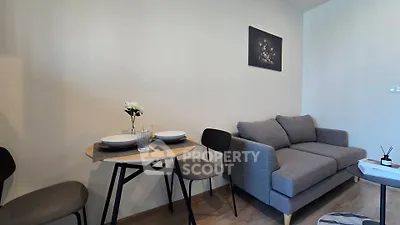 Cozy living room with modern gray sofa and dining area