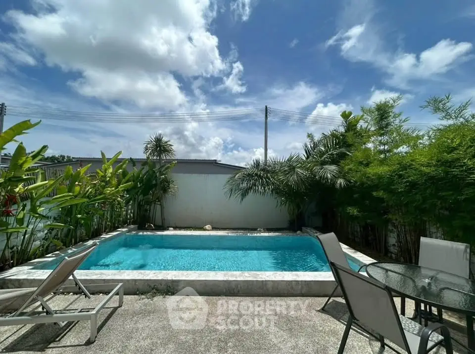 Stunning backyard pool oasis with lush greenery and modern patio furniture.