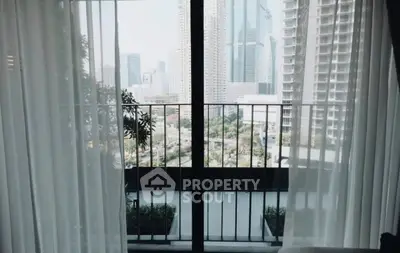 Stunning city view from modern apartment balcony with floor-to-ceiling windows.