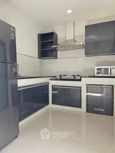 Modern kitchen with sleek cabinetry and gas stove, perfect for culinary enthusiasts.