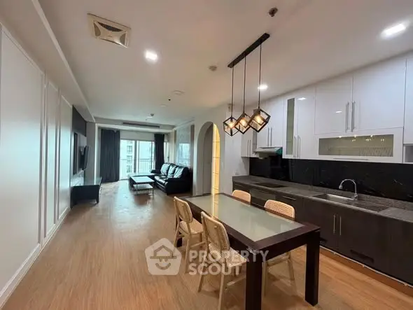 Spacious modern living room with open kitchen and elegant dining area in luxury apartment.