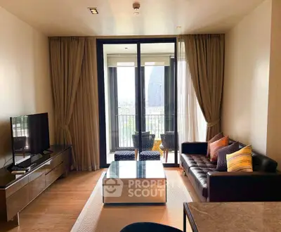 Modern living room with balcony view, stylish furniture, and natural light in a high-rise apartment.