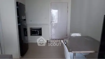 Modern kitchen with sleek appliances and dining area in a contemporary apartment.