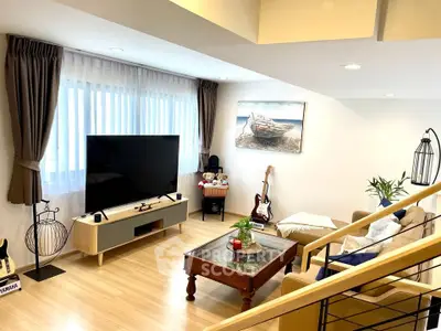 Stylish living room with modern decor, large TV, and cozy seating area, perfect for relaxation.