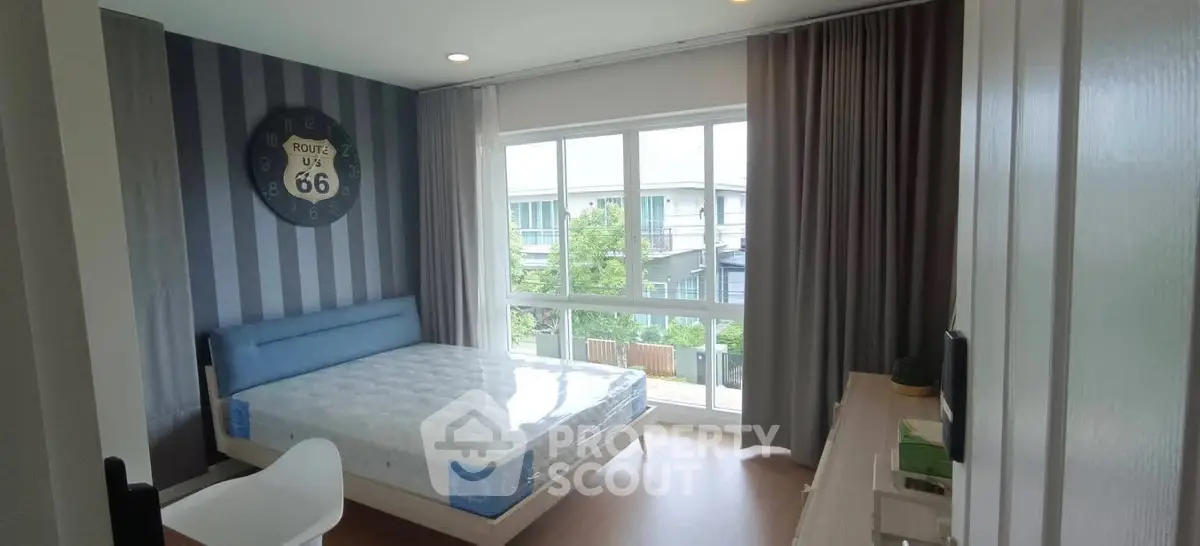 Modern bedroom with large window and stylish decor in a contemporary home.