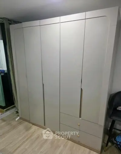 Spacious modern wardrobe in a stylish bedroom setting with wooden flooring.