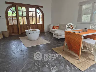 Spacious living room with stylish flooring and elegant wooden doors