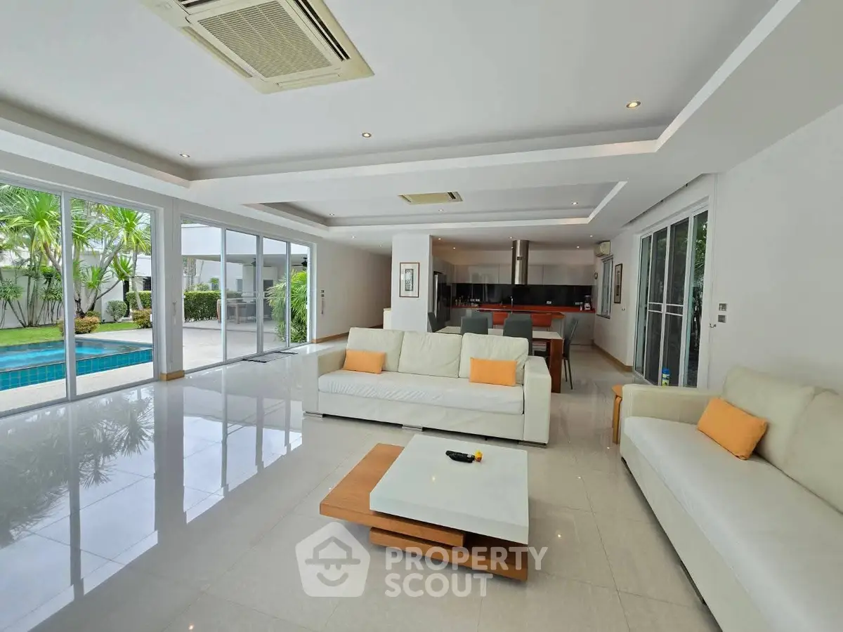 Spacious modern living room with pool view and open kitchen layout