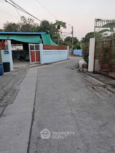 Charming residential street view with gated homes and lush greenery, perfect for serene living.