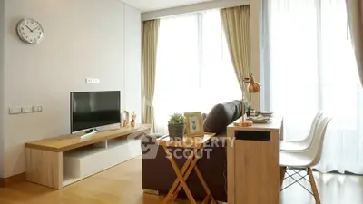 Modern living room with stylish decor and natural light, featuring a cozy sofa and sleek TV stand.