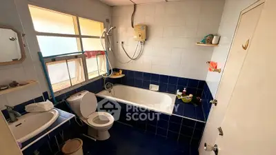 Spacious bathroom with bathtub and modern fixtures in a well-lit setting.
