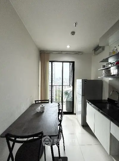 Modern kitchen with dining area and balcony view in urban apartment