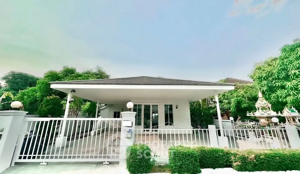 Charming single-story home with spacious driveway and lush greenery