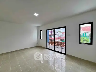 Spacious living room with large windows and tiled flooring in modern home