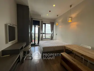 Modern bedroom with balcony view, featuring stylish furniture and ample natural light.