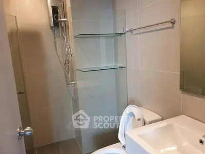 Modern bathroom with glass shower and sleek fixtures in a contemporary apartment.