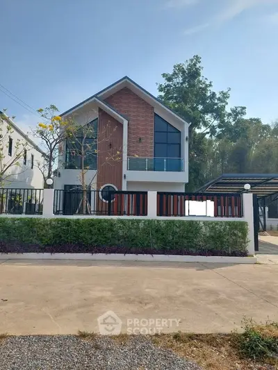 Modern two-story house with large windows and stylish facade in a serene neighborhood.