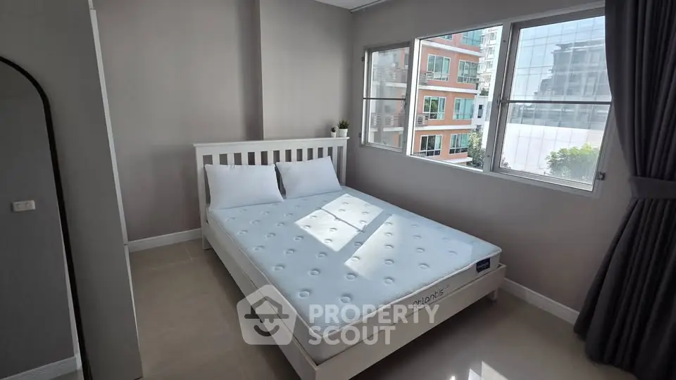 Bright bedroom with large windows and modern decor in urban apartment