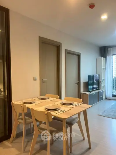 Modern living room with dining area and TV, featuring contemporary furniture and stylish decor.