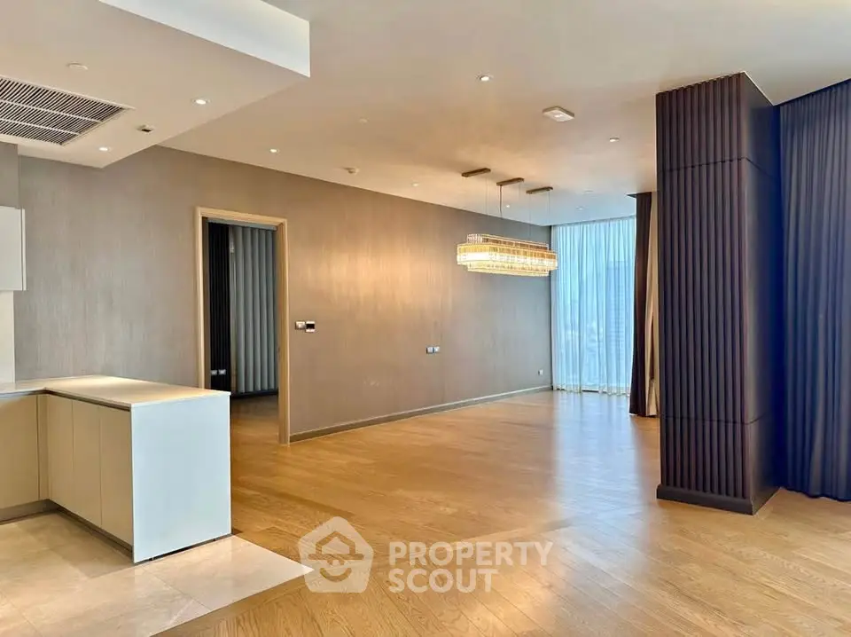 Spacious modern living room with elegant lighting and hardwood floors in luxury apartment.