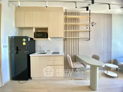 Modern kitchen with sleek cabinetry and dining area in stylish apartment.