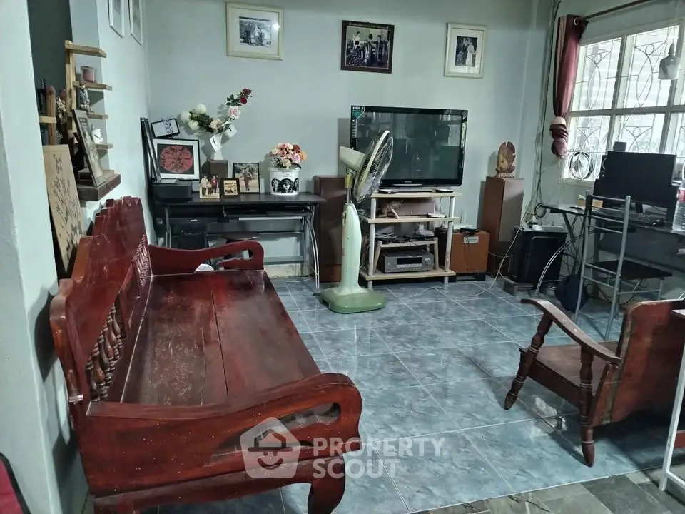 Cozy living room with wooden furniture and modern entertainment setup, perfect for relaxation and family gatherings.
