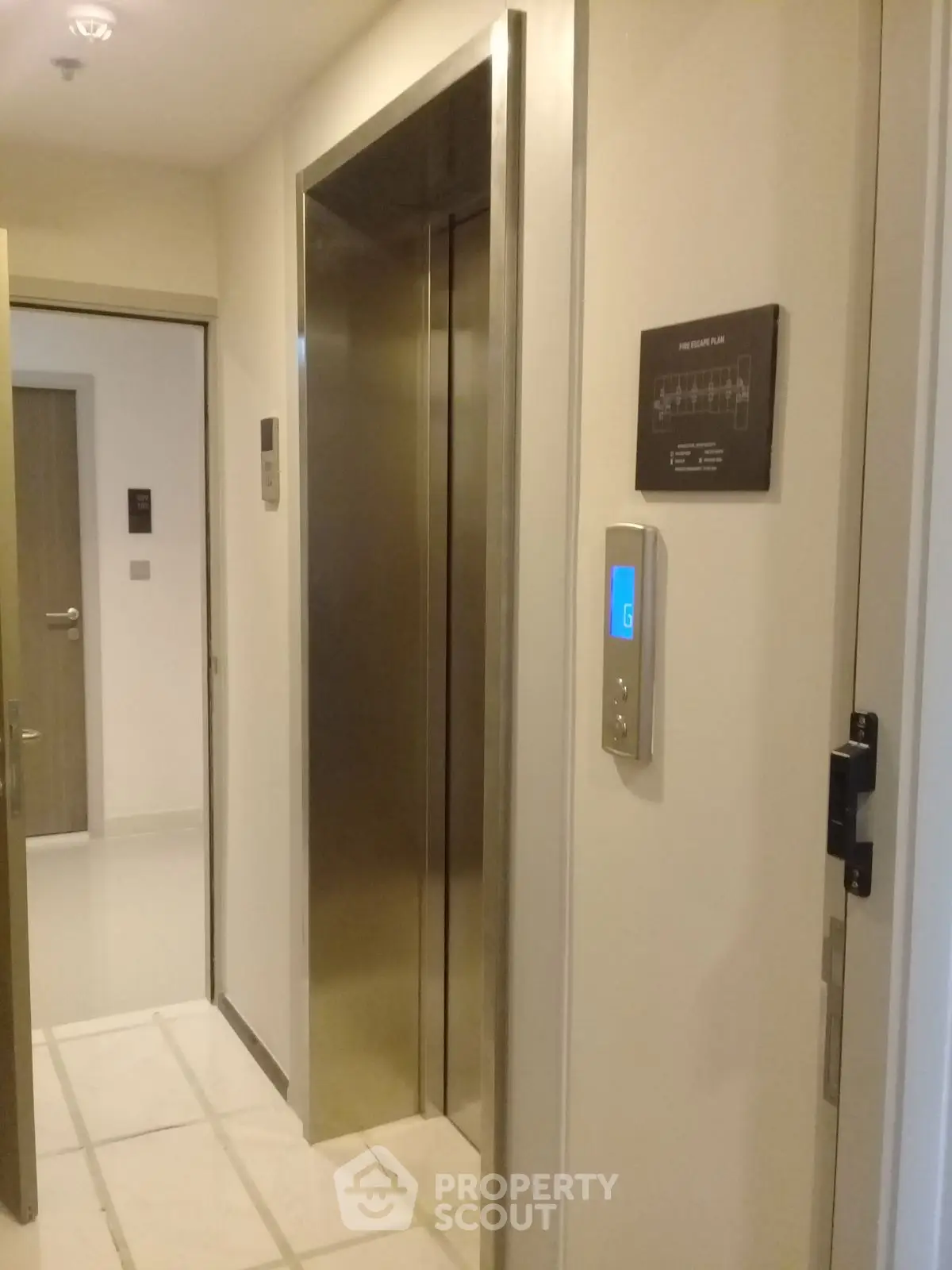 Modern building elevator with sleek stainless steel doors and digital floor indicator.