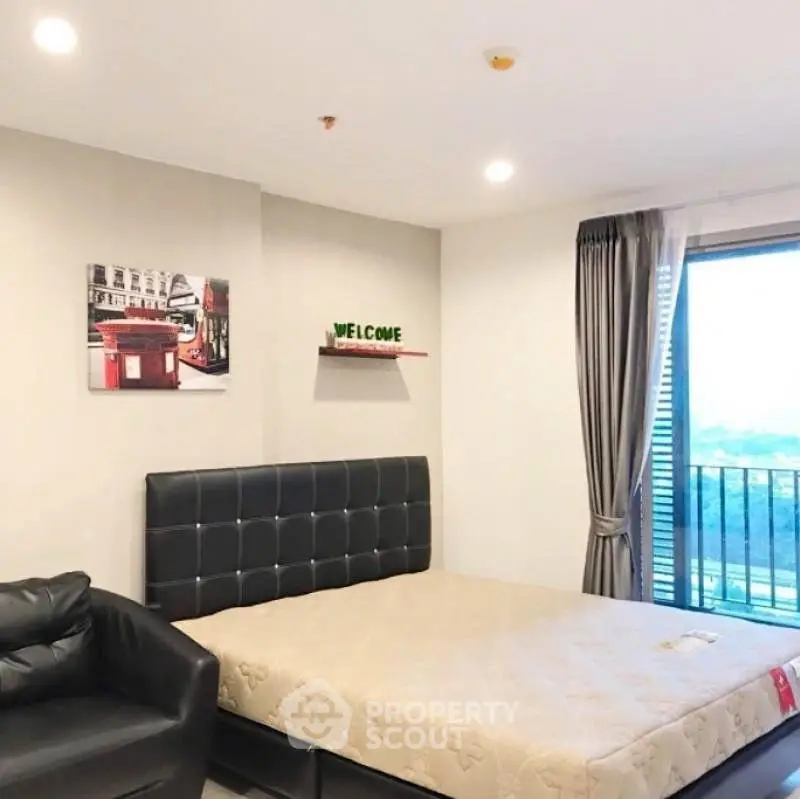 Modern bedroom with stylish decor and large window offering scenic views.