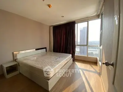 Spacious bedroom with large windows and city view, featuring a comfortable bed and modern decor.